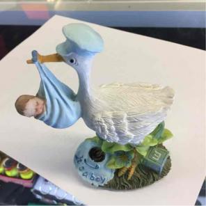 stork carrying baby boy figurine